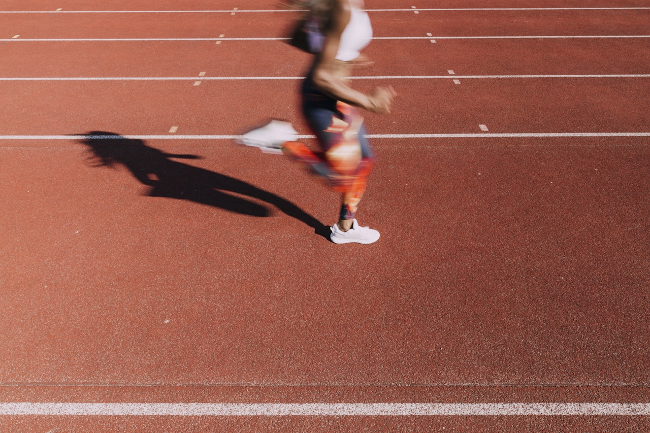 A runner in motion on a red track